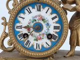 a gold clock with a blue and white clock face