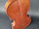 an old violin sitting on top of a black surface