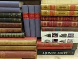 many books stacked on top of each other on a table