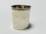 a silver cup that is sitting on a white surface