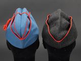 two pairs of hats with tassels on top of them on a black surface