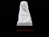 a white statue of a woman sitting on a table