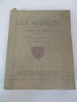 un vieux livre posé sur une table à côté d'une tasse de café