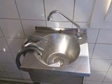 un lavabo dans des toilettes publiques équipé d'un sèche-mains