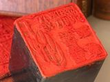 a red wax stamp sitting on top of a wooden box