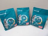 trois sacs de nourriture pour chat posés sur une table