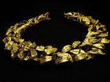 a close up of a gold necklace on a black background