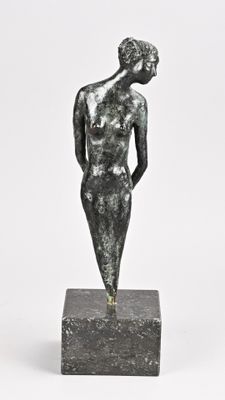 statue d'une femme debout sur un socle, les mains sur les hanches