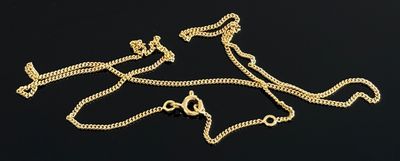 deux chaînes en or et un collier posés sur une surface noire