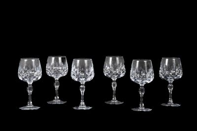 six verres à vin sont alignés sur un fond noir