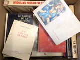 plusieurs livres superposés dans une boîte