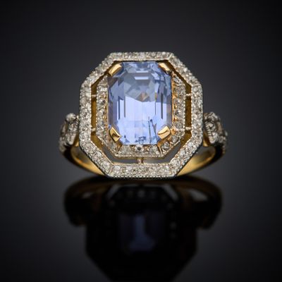a blue sapphire and diamond ring on a black surface