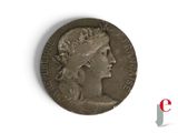 une vieille pièce de monnaie sur laquelle figurent la tête d'une femme et une couronne