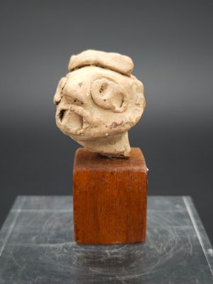 une image représentant une sculpture représentant une tête d'homme posée sur un bloc de bois