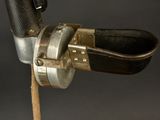 a close up of a metal object with a wooden stick