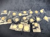 some gold coins are in plastic bags on a black surface