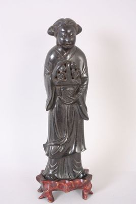 une statue ancienne représentant une femme tenant une fleur sur un socle