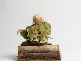 a statue of a woman sitting on top of a pile of books