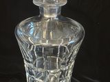 a clear glass bottle with a stopper on a black background