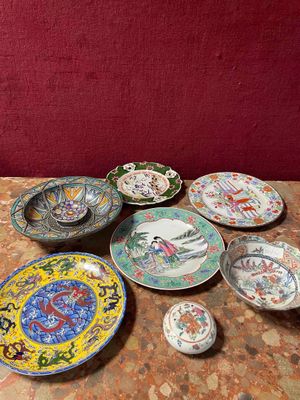many plates and bowls sitting on a table with a red wall in the background