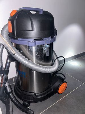 a vacuum that is sitting on the floor next to a wall