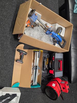 une boîte remplie d'outils posée par terre dans le salon