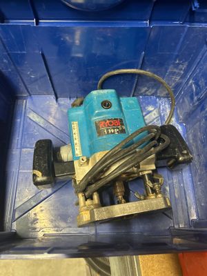 une boîte bleue contenant une perceuse et un cordon