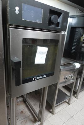 un four en acier inoxydable dans une cuisine dotée de nombreux plans de travail
