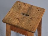 a small wooden stool with a hole in the top of it