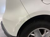 a close up of a white car with a denting on the side of it