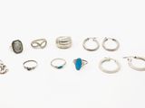 plusieurs bagues et boucles d'oreilles différentes posées sur une surface blanche
