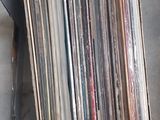 beaucoup de disques dans une boîte posée par terre
