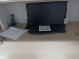 un ordinateur portable posé sur un bureau, à côté d'un clavier
