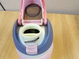 a pink and blue cup with a lid sitting on a table