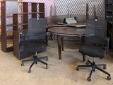 three chairs and a table in a room with a bookcase