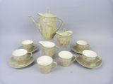many cups and saucers and a teapot on the table