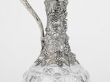 une image représentant un pichet en argent et en verre sur fond blanc