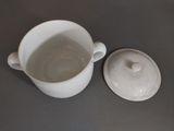 a white cup with a lid sitting on a table