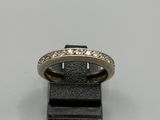 un gros plan d'une bague posée sur un support noir, sur une surface blanche