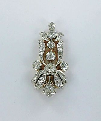 un gros plan d'une broche en diamant posée sur une surface blanche