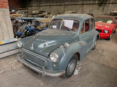an old car parked in a garage with other cars in the background
