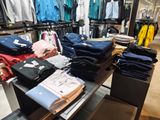 a lot of shirts on a table in a store