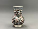 un vase orné d'un motif floral sur un fond gris