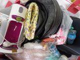 un tas d'articles pour bébé dans une valise posée sur un lit