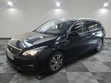 une voiture noire est garée dans une pièce au sol en damier