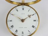 a gold pocket watch with roman numerals on the face