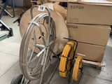 un chariot sur lequel sont empilées des boîtes et un tuyau, dans un entrepôt