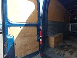 a blue van with a wooden door open on the street