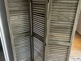 a room divider made out of old shutters on the floor