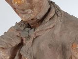 a clay statue of a man with a tie on his neck